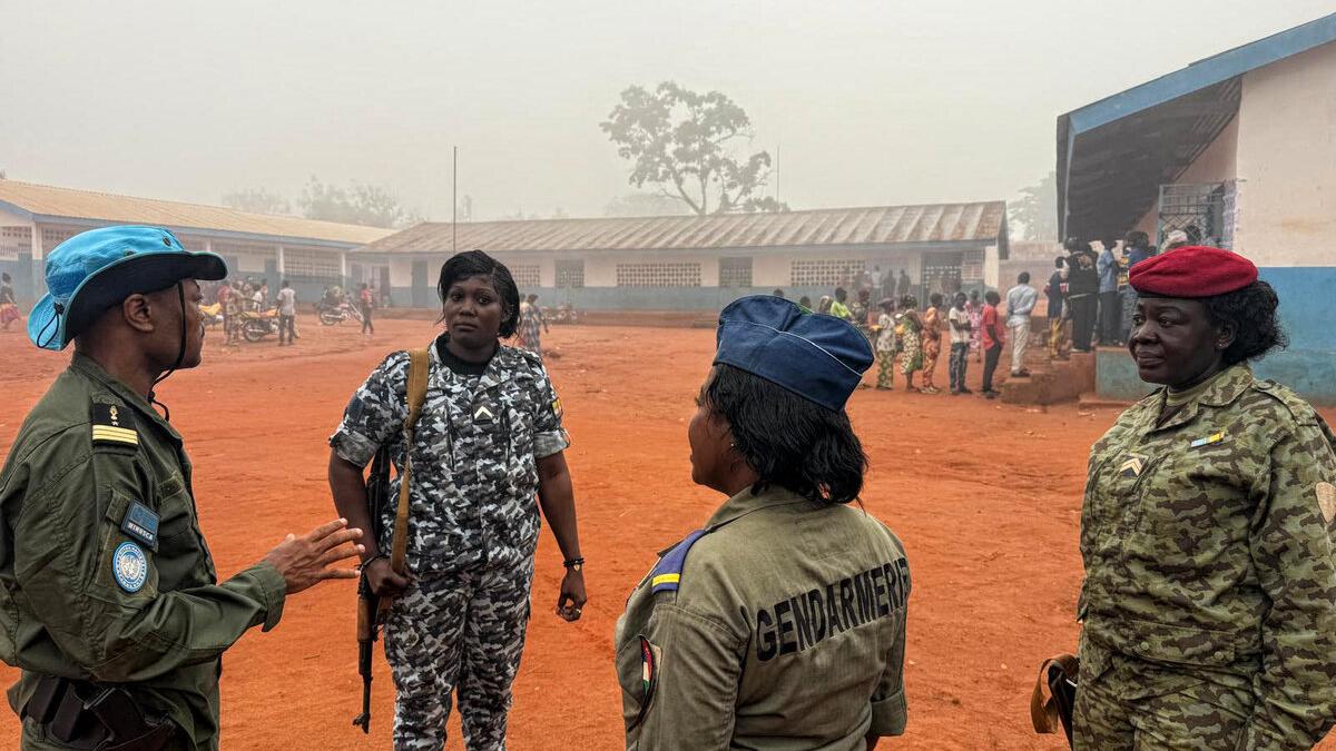 Du personnel militaire et policier se tient à l’extérieur.
