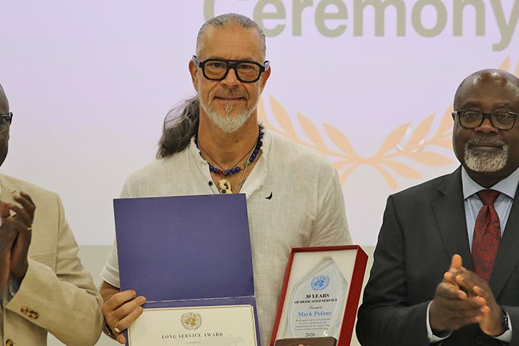 Mark Polane (c) shows his 30 year Long Service Awards presented to him by RSCE Director, Paulin Djomo (r) and Chief RFTS, Emmanuel Ngor (l) Chief RFTS, Emmanuel Ngor, Awardee Mark Polane and RSCE Director, Paulin Djomo